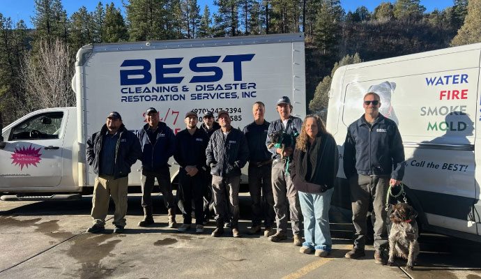Best Cleaning and Restoration team posing with company vehicles