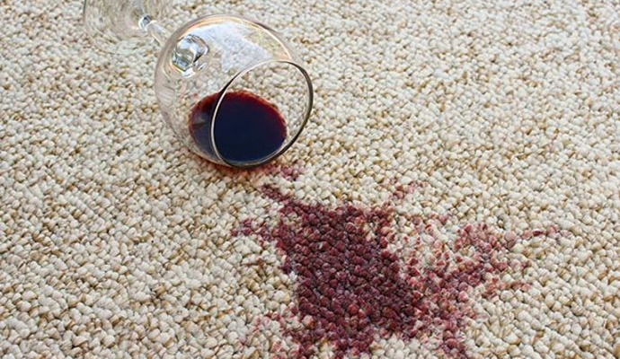 Spilled red wine leaving a visible stain on the carpet