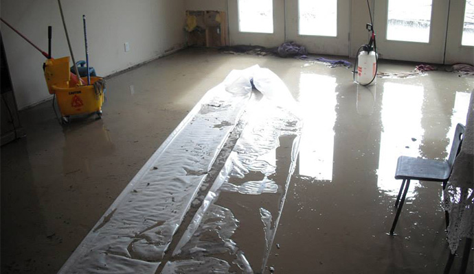 A room's floor covered in muddy flood water A room's floor covered in muddy flood water