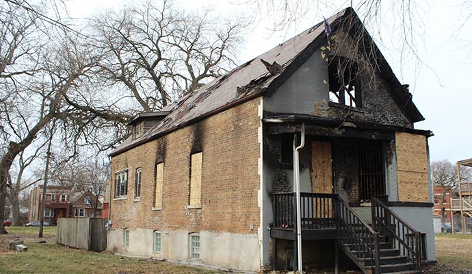 Boarded up fire damaged house