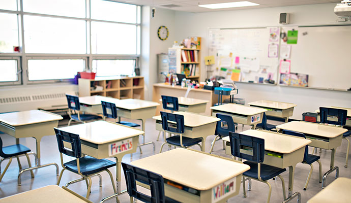 Empty school classroom with student desks and whiteboard