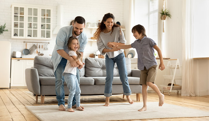Happy family standing in a clean restored home living area
