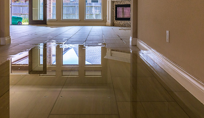 Flooded living room with standing water on tile floors
