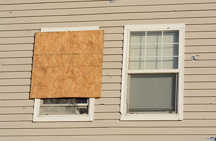 boarded-up storm-damaged window