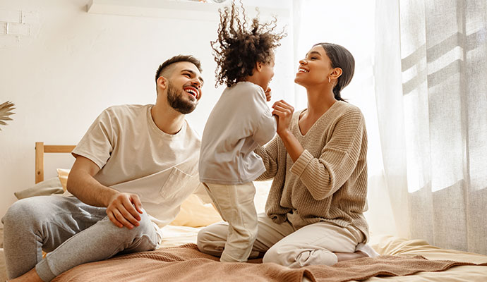 Happy family playing together on a bed