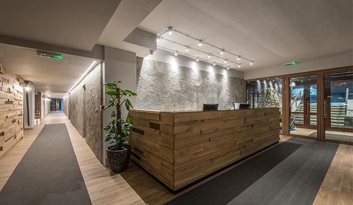 A modern hotel lobby with a rustic wooden reception desk