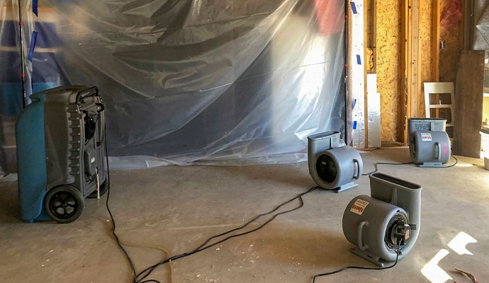 Industrial dehumidifier and air movers in room under renovation