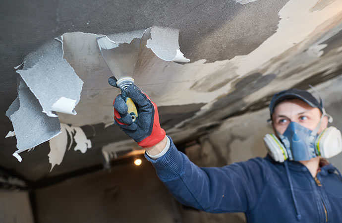 a worker cleaning up smoke spots on the ceiling