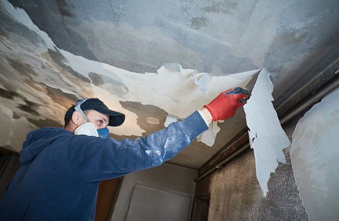 a worker cleaning up smoke spots on the ceiling