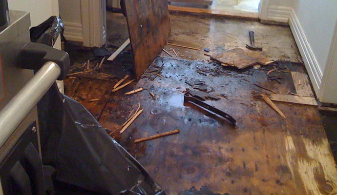 Water damage on wooden floor with visible warping and discoloration