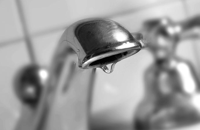 water drop dripping from the tap leaky faucet