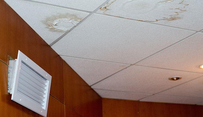 Water stains on drop ceiling tiles near air vent