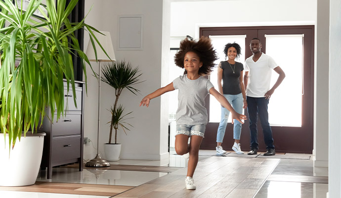 Young girl running happily through a bright home